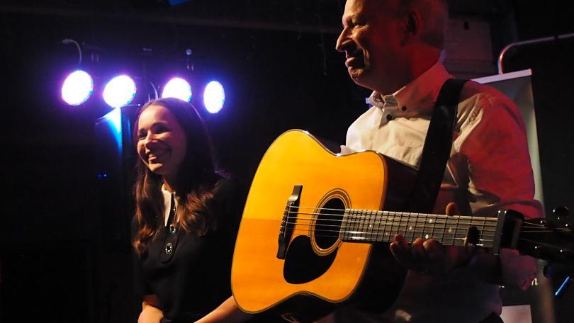 Image of Louise and Chris Rogan. Louise is singing and Chris is playing guitar.