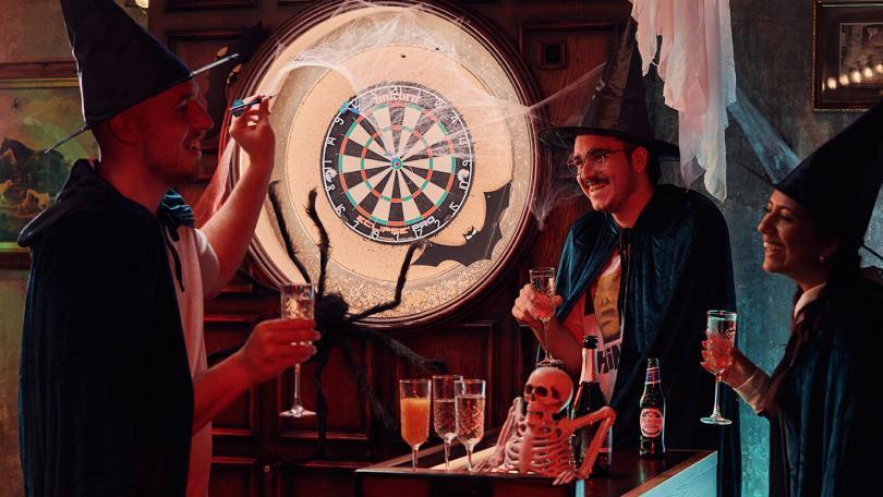 People playing darts in Halloween fancy dress