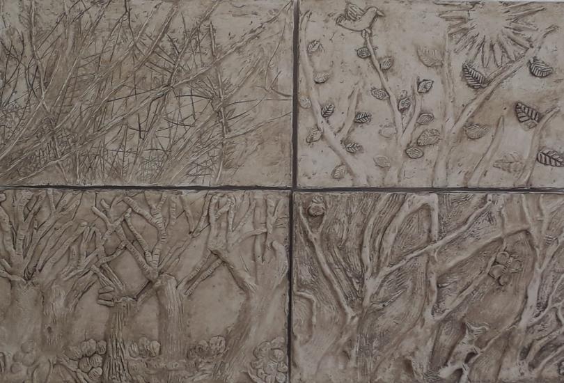 White relief artwork showing trees in four seasons