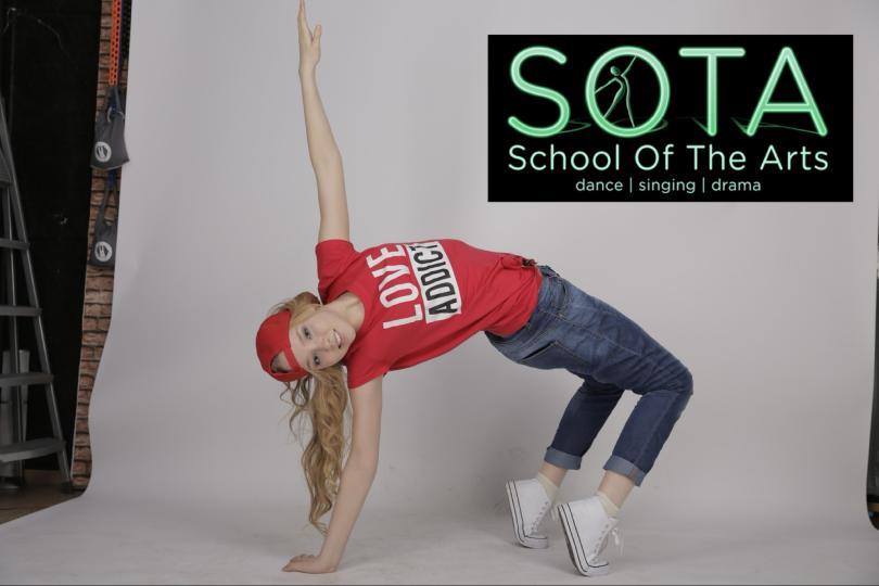 Photo of blonde dancer in a back bend wearing trainers, red t-shirt and baseball cap.