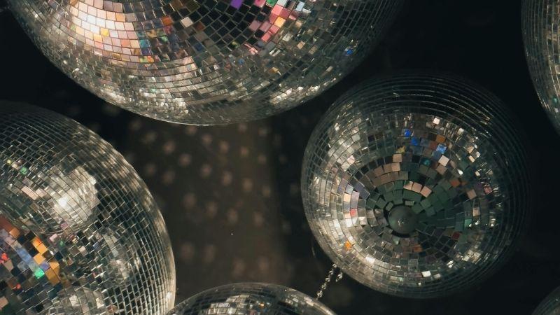 The image shows a close up of different sized silver disco balls.