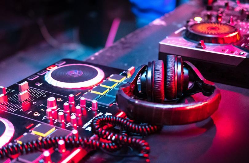 Stock image of mixing desk and headphones bathed in blue and pink lights