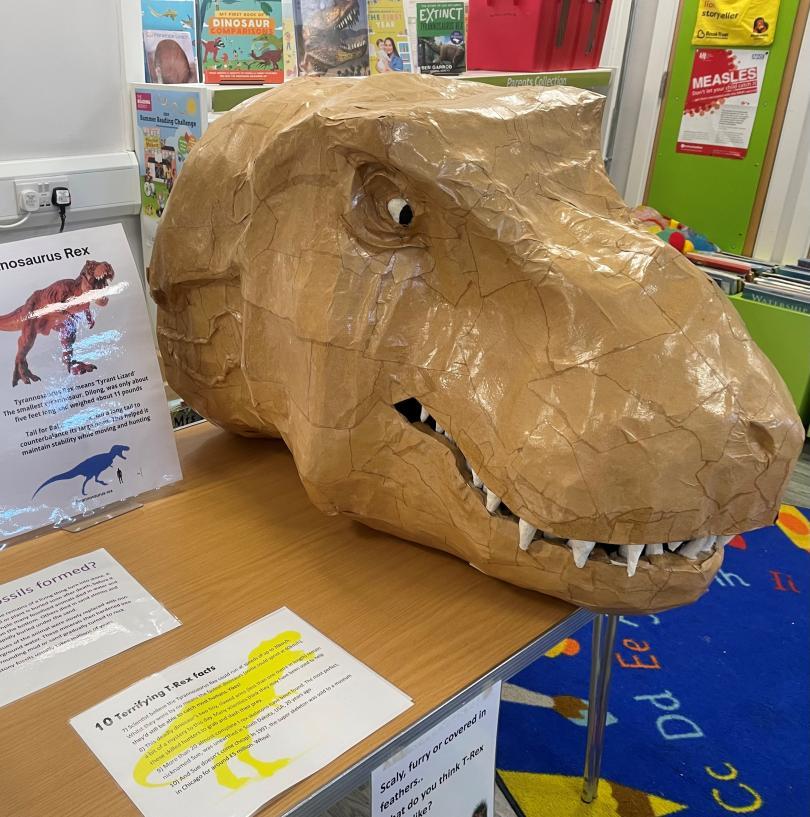 Photograph of a large craft made TREX cardboard head on a desk