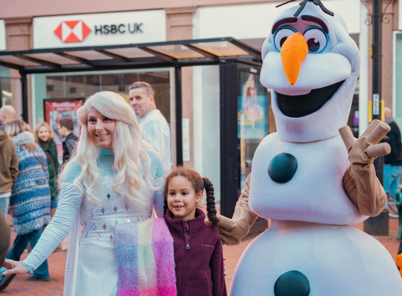 Snow Queen and Huggable Snowman with a child on Broad Street