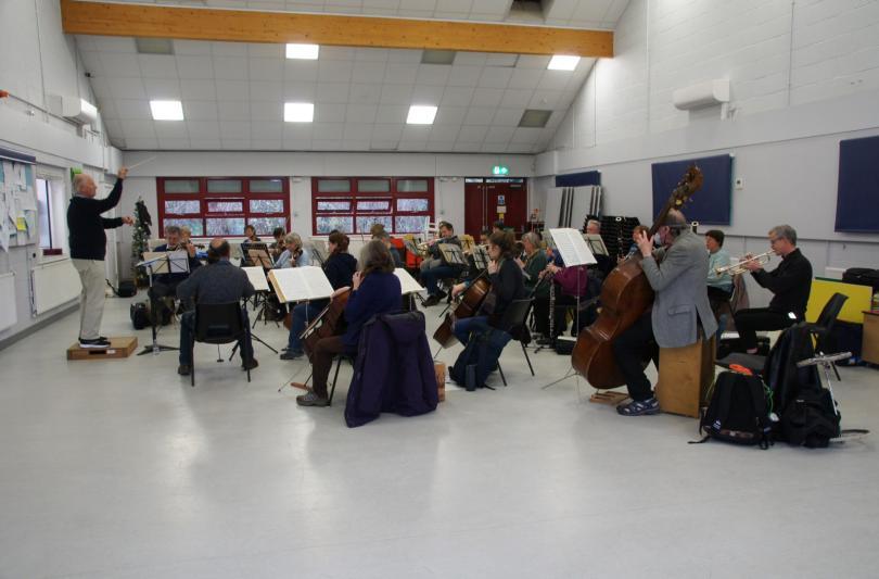Orchestra members in a community hall