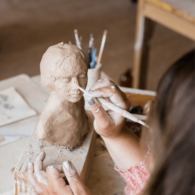 Hand sculpting a clay statue