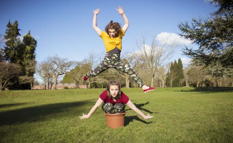 Dancer in a plant pot, with another dancer jumping above them