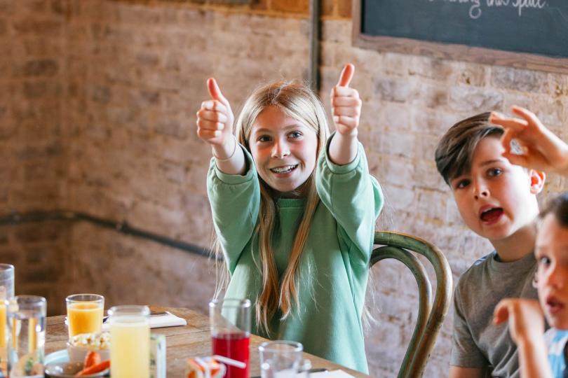 Kids eating pancakes and giving thumbs up