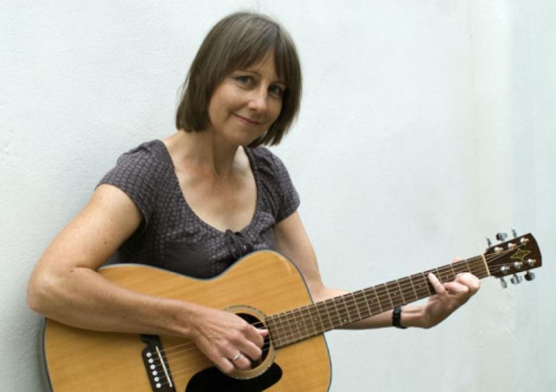 Photo of Liz Simcock with a guitar