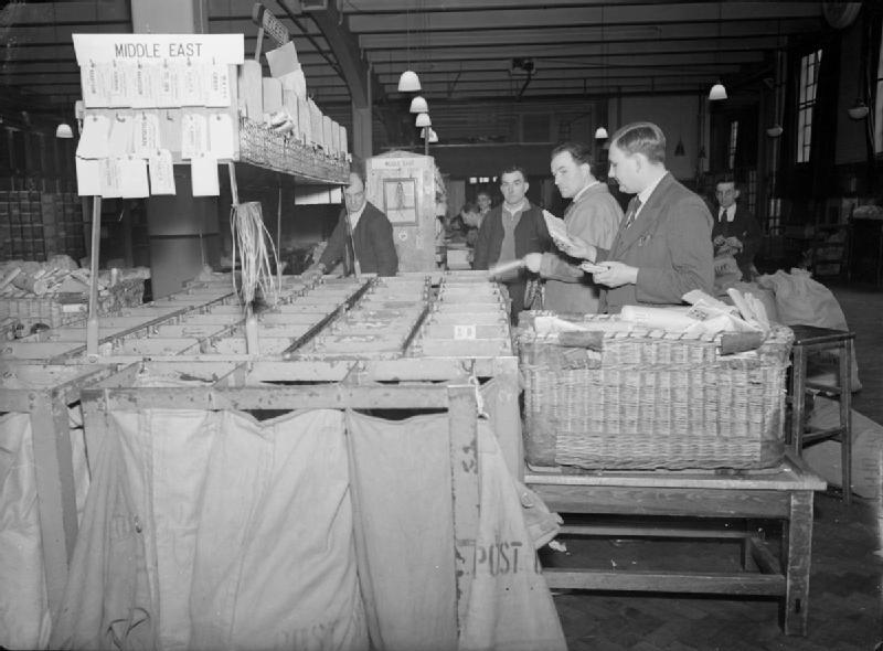 men in a middle east mail room in wartime