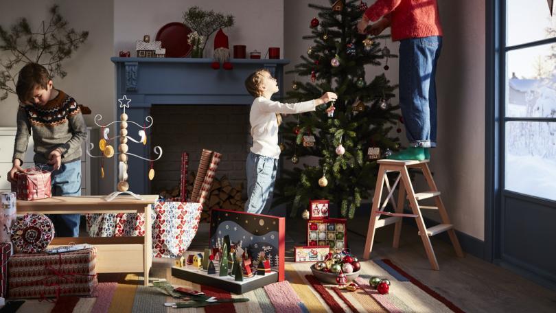 A young boy putting up festive decorations in their home 