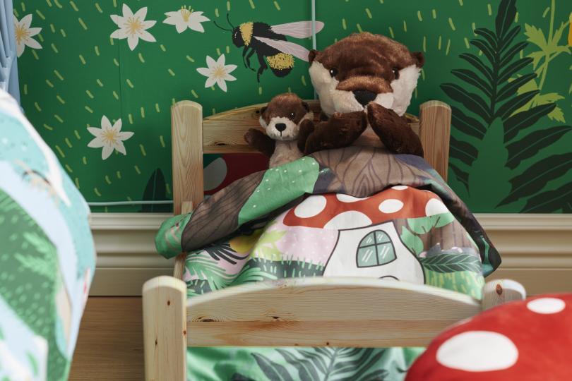 Mother and baby otter sat in bed 