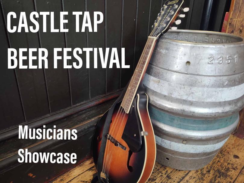 Mandolin leaning against a metal beer firkin on pale wooden floor with dark wooden panelling  to the left side
