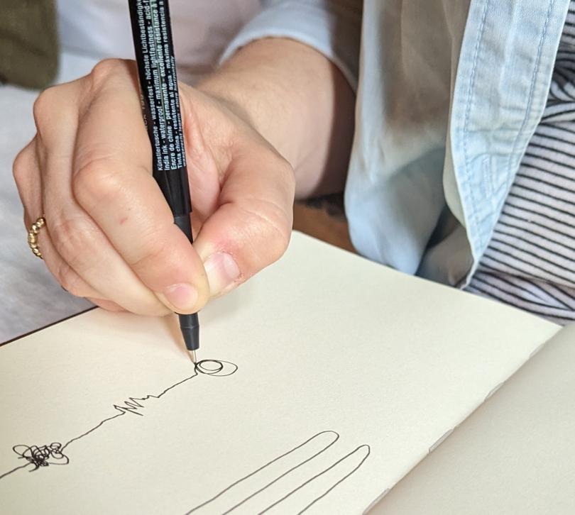 Image of a hand drawing lines on a page