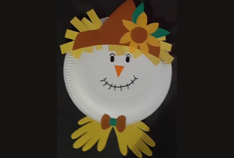 Photograph of a scarecrow's face made from a paper plate