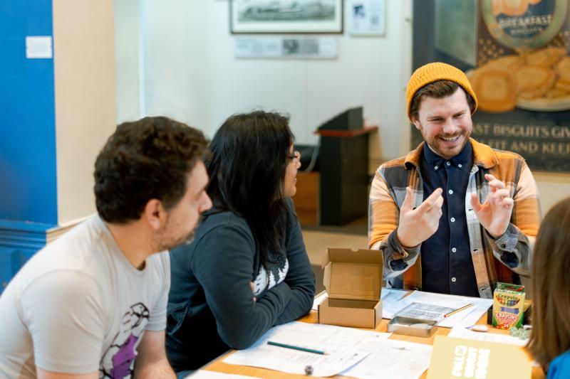 Group of young people sat around a table playing dungeons and dragons