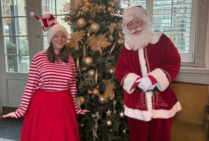Santa and his Elf beside a Christmas tree