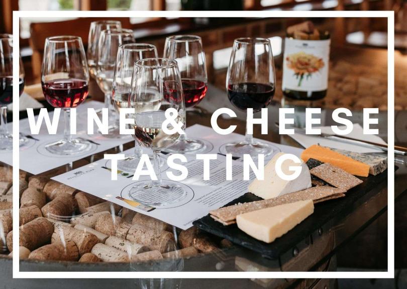 White text: Wine & Cheese Tasting, behind it is a table of wine glasses and cheese board 