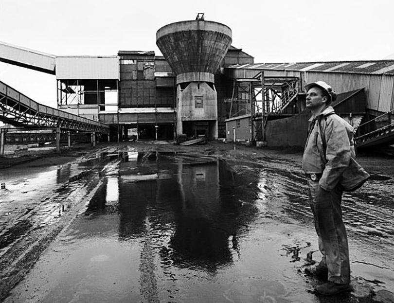 A coal miner standing in front of a mine