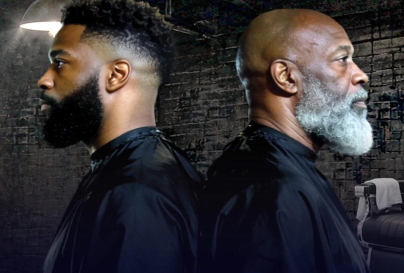 Two black men, back to back, wearing barber's bibs