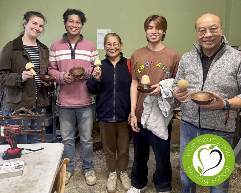 A family of five holding their turned mushrooms and bowls.