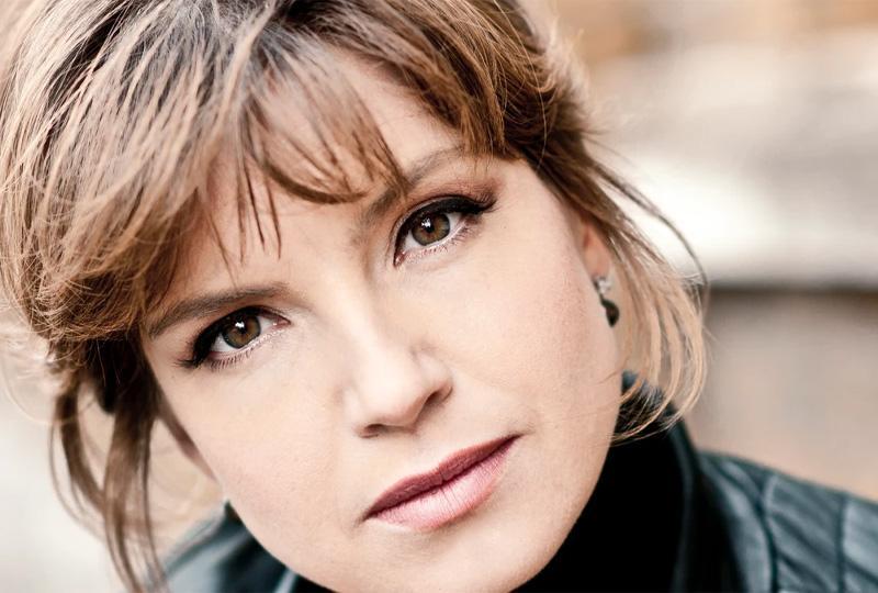 Claire Booth, a woman with brown hair wearing a leather jacket
