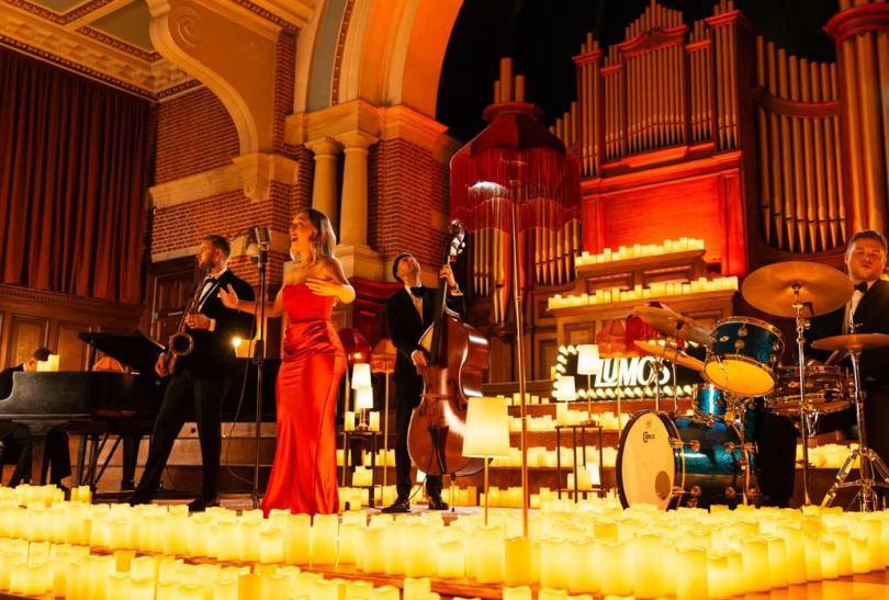 Jazz band performing on stage surrounded by candlelight