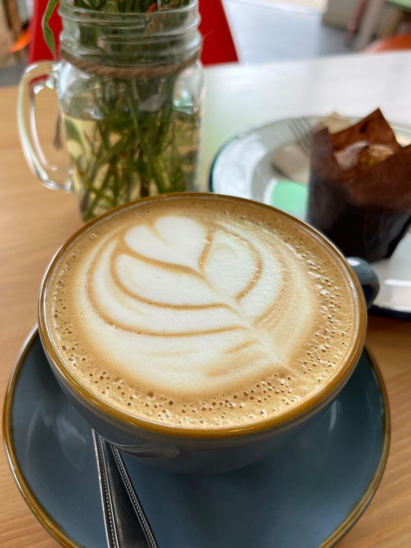 Latte art, muffin and plant