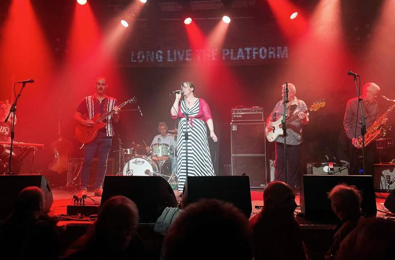 Blues band on stage under red lights
