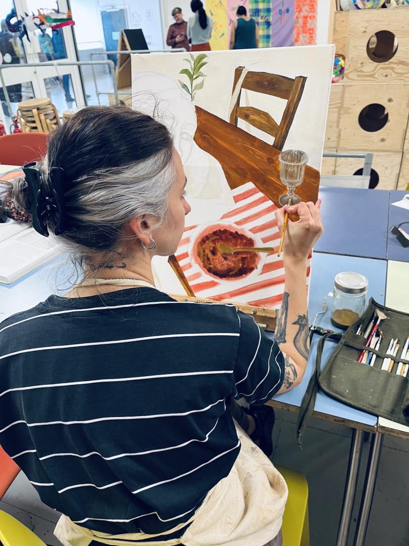 back of woman's head over her painting 