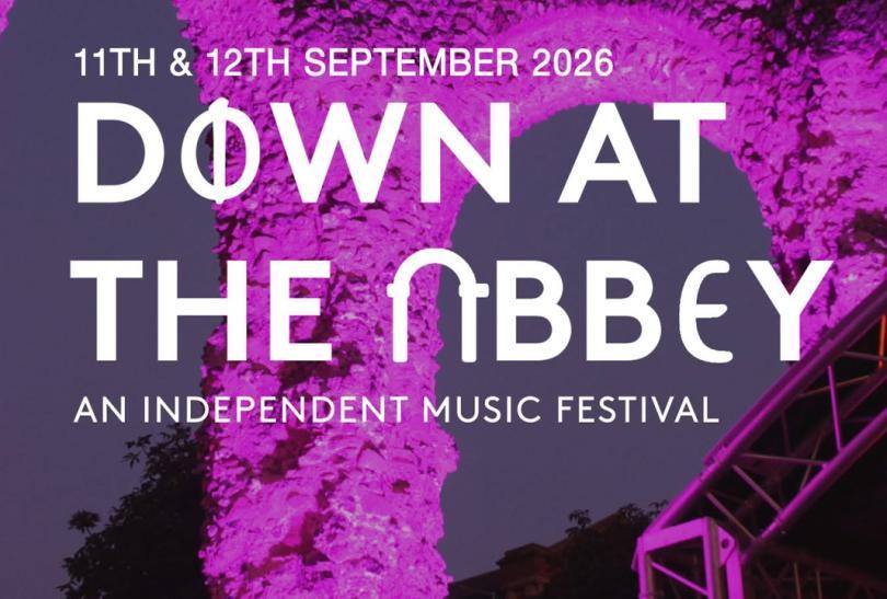 Down At The Abbey event poster with logo over a photo of the Abbey Ruins