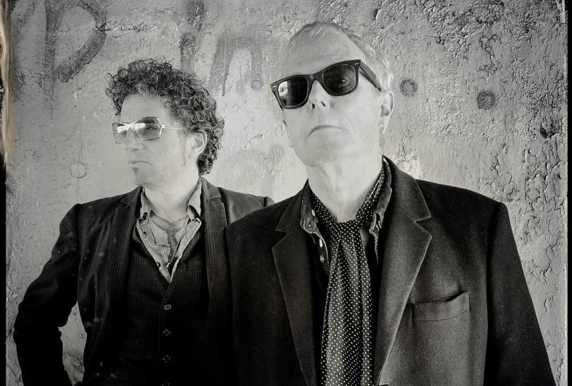 Black and white photo of two middle-aged men in sunglasses and leather jackets