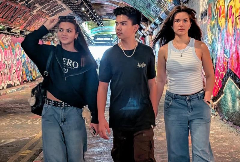 Three teenage punks standing in a grafitti'd tunnel