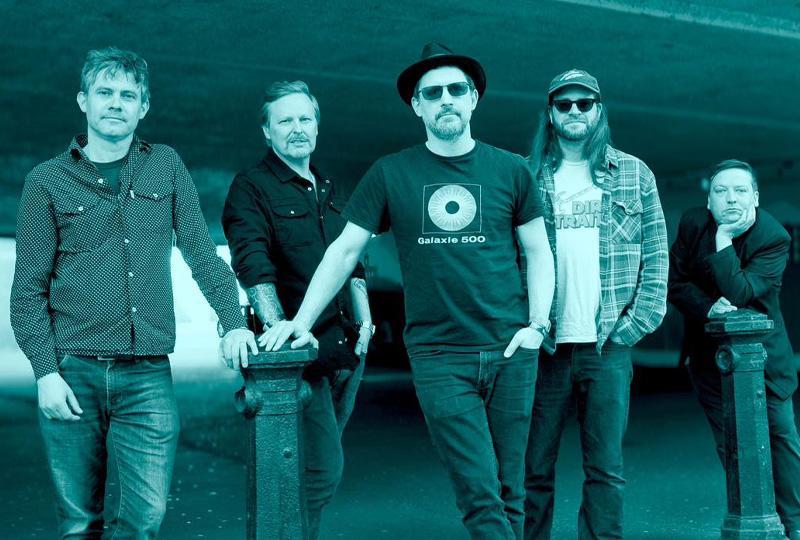 Green monochrome photo of five members of Dreaming Spires band, standing in an urban environment