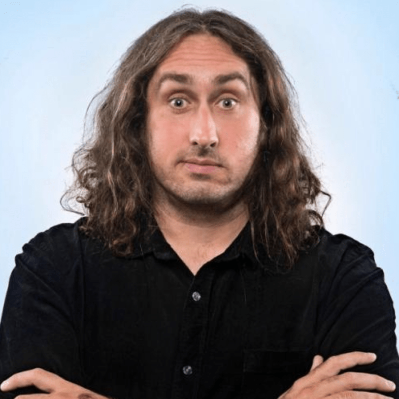 Ross Noble - man with long hair on blue background 