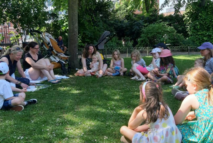 Children sitting in a circle in Forbury Gardens