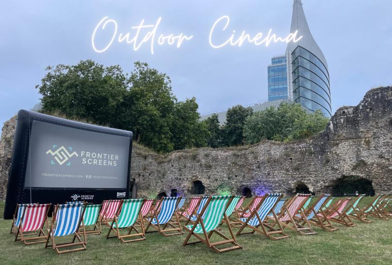 Outdoor cinema screen in Reading Abbey Ruins, surrounded by deckchairs