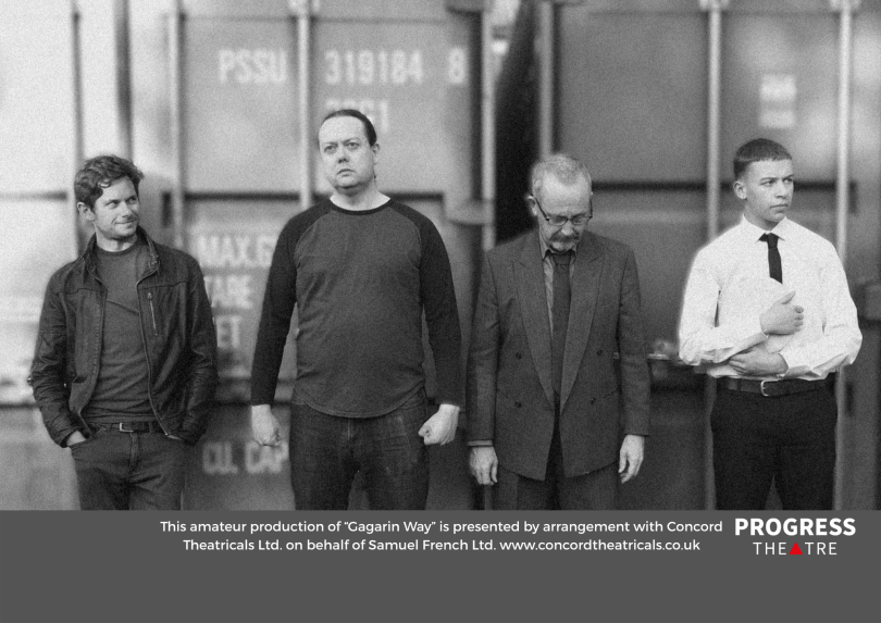 Grainy black and white image of four men standing a row with details of the production at the bottom