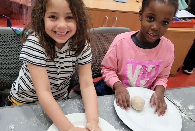 Young girls rolling dough