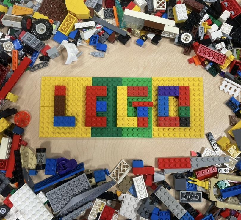 Lego figures holding a LEGO globe