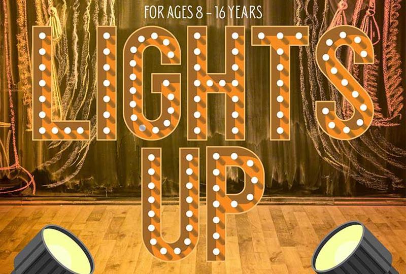 The word "lights up" spelt out in theatrical lettering with lightbulbs