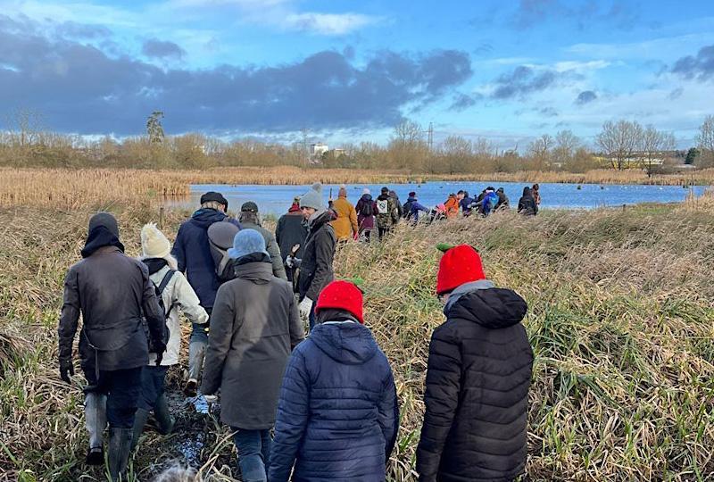 Group of people marching through marshland