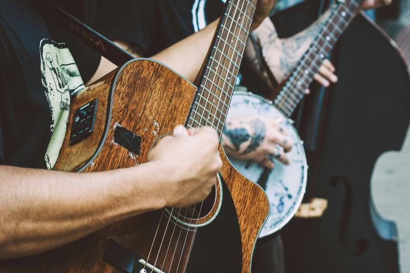 Stock image of people playing instruments; an acoustic guitar, banjo & double bass