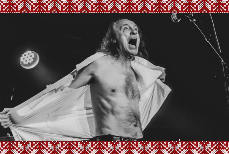 Black and white photo of singer John Otway ripping open his shirt