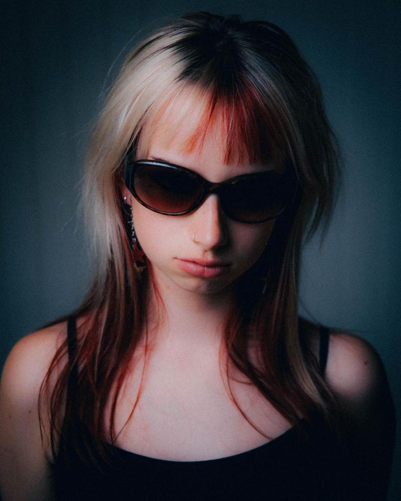 Close up photo of singer Patchy Blonde with blonde hair and dark sunglasses