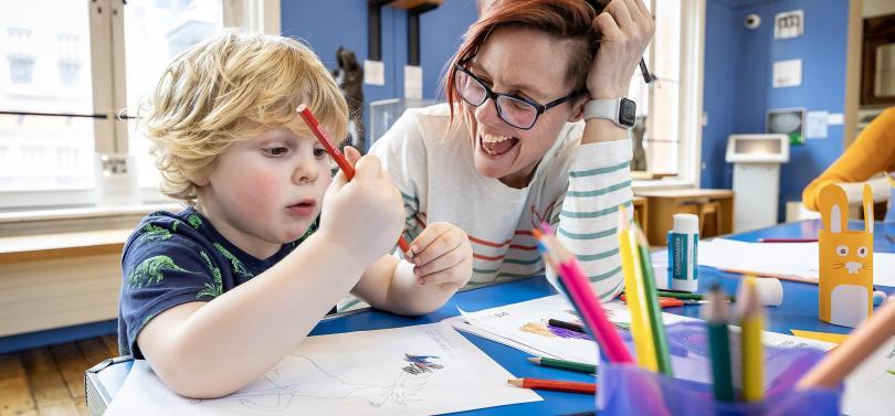 child and museum worker doing crafts
