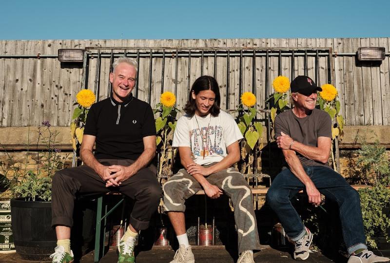 Red Snapper sitting on a bench in front of a fence in the sunshine