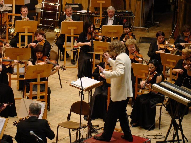 Orchestra with a conductor in a white dinner jacket
