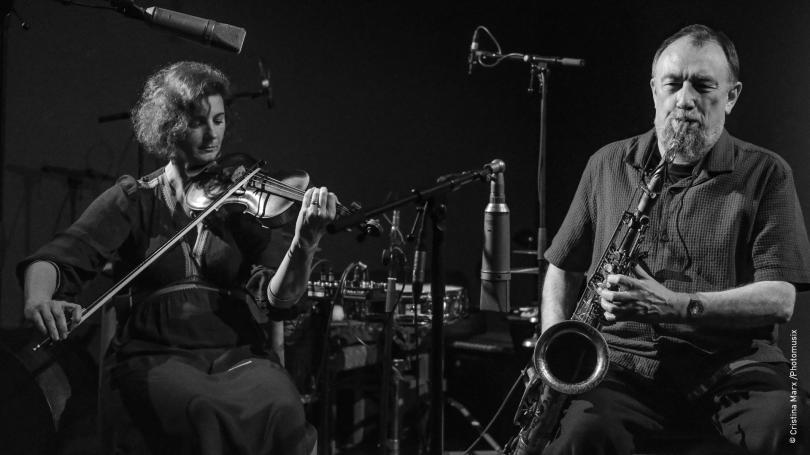 Black and white photo of John Butcher on the saxophone and Angharad Davies on the violin