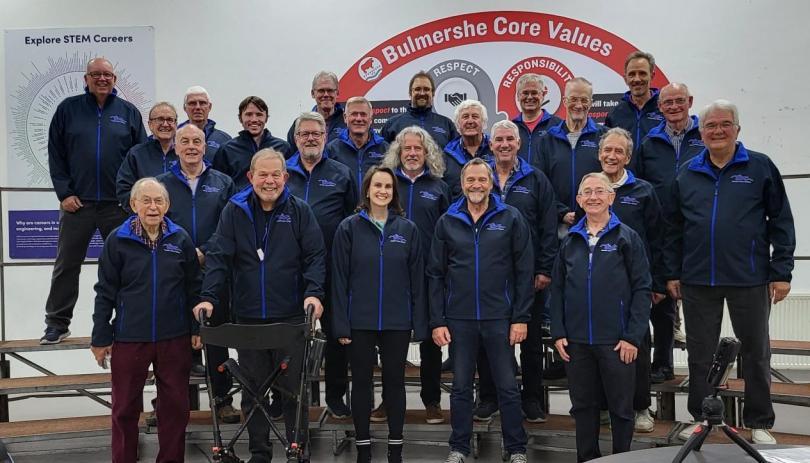 Thames Valley Chorus on stage in new blue fleeces